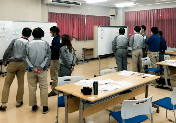 打合せをする作業服の男性社員たち