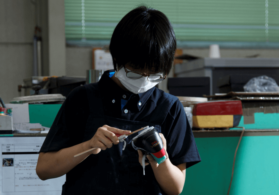 靴底をブラシでこする社員