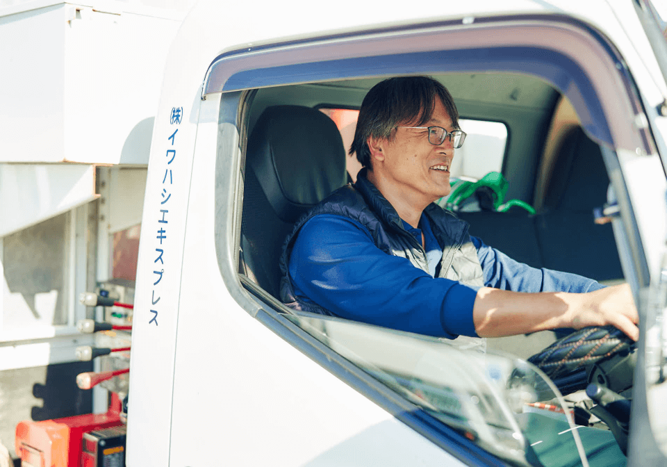 トラックの席に座る作業員