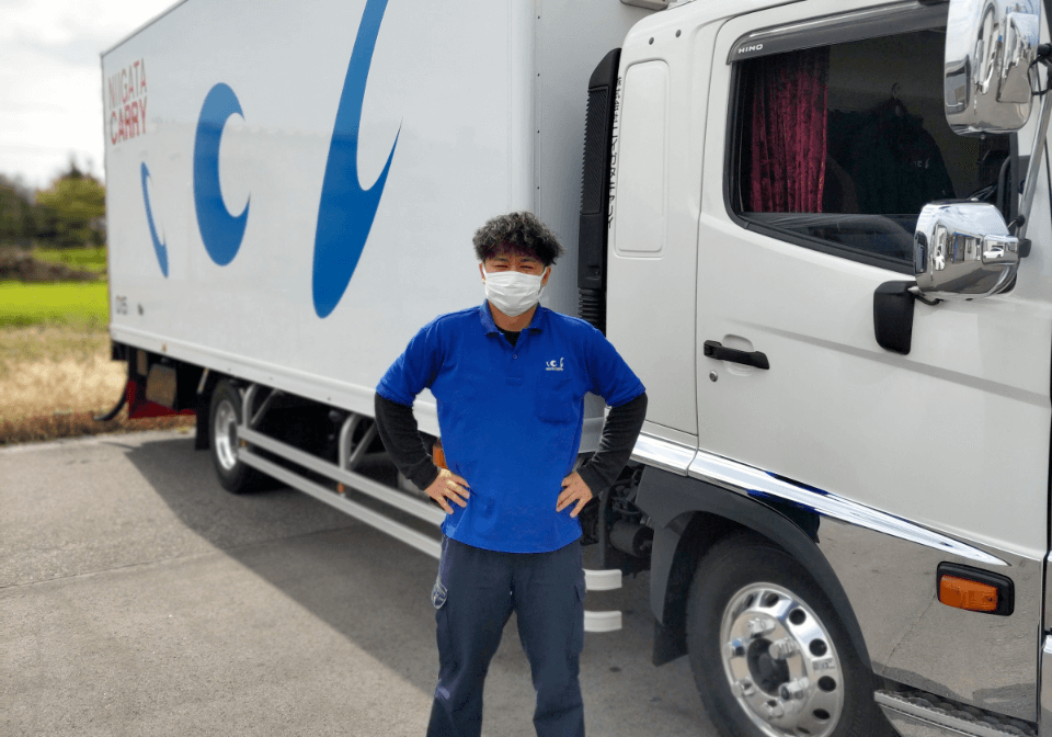 トラックの前に立つ男性スタッフ