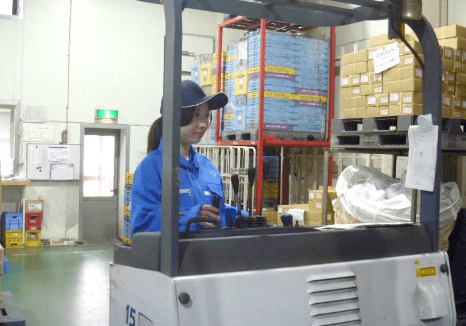 フォークリフトを運転する女性スタッフ