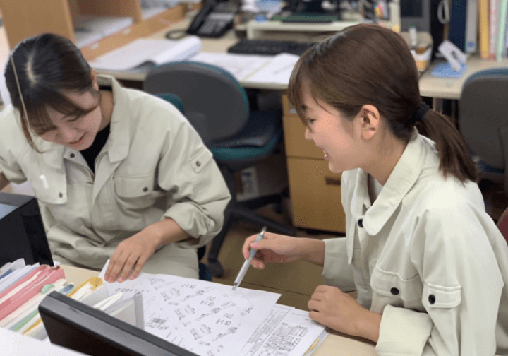 笑顔で相談している女性社員たち