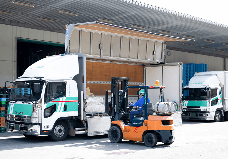 フォークリフトで荷物を運ぶ男性スタッフ