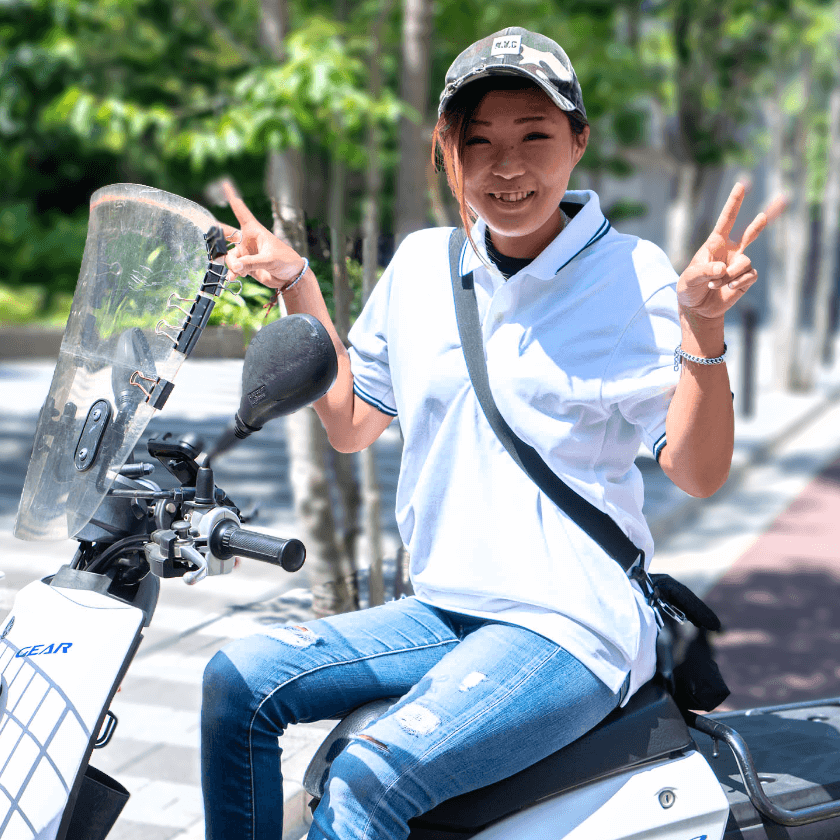 笑顔でバイクに乗っている女性  スタッフ