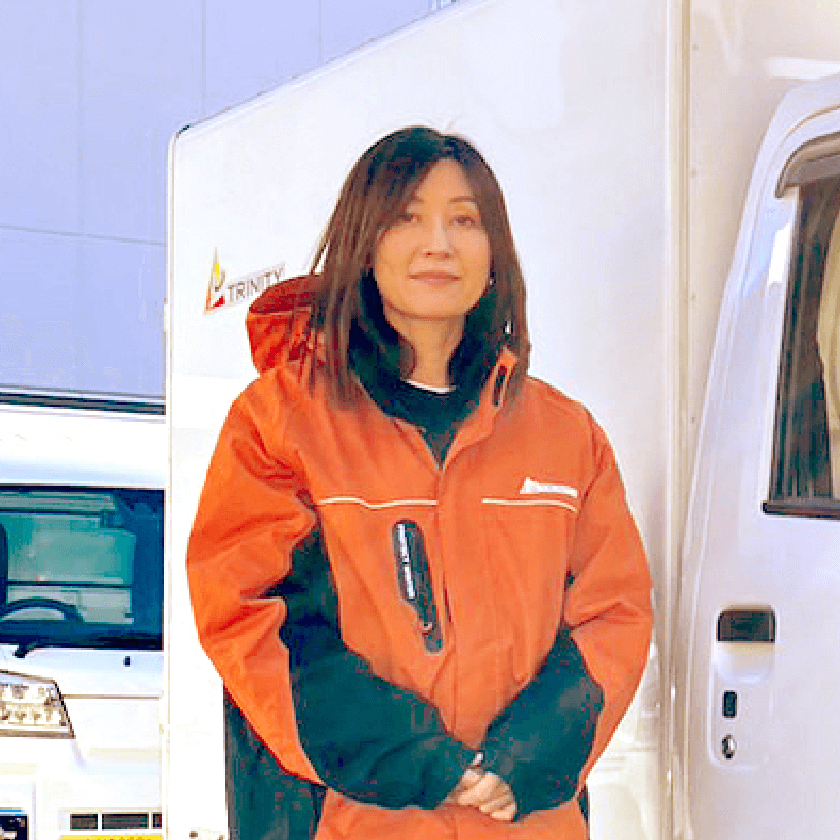 トラックの横に立つ女性ドライバー