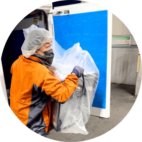 商品を下ろしているスタッフ